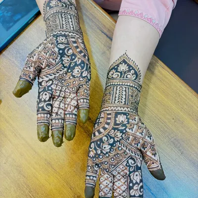 A beautiful Arabic-style design on the back of the hands. The pattern is dense with bold floral motifs and delicate shading, creating a striking contrast.