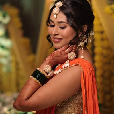A splash of orange, a dash of glow. This Haldi makeup look is all about radiant skin, shimmery eyes, and a fun, messy braid that steals the show.