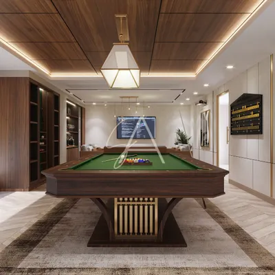 This billiard room was designed to be a sophisticated entertainment hub. The professional-grade pool table is the centerpiece, complemented by a herringbone wood floor and custom cabinetry for a modern, regal feel.
