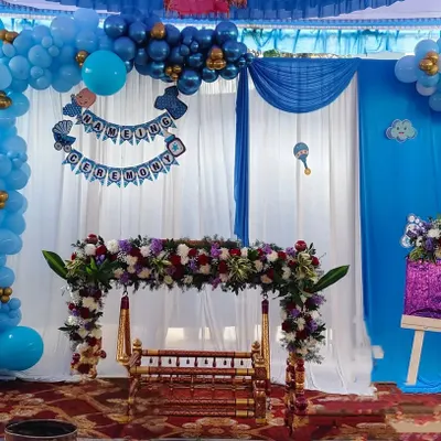 Here is a beautiful setup for a traditional Namakarana or naming ceremony. We decorated the wooden cradle, or thottilu, with fresh flowers and created a backdrop with blue balloons and soft white drapes to welcome the little one.