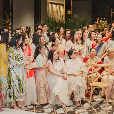 When the best moments come from people, not plans. This shot captures the joy of the guests as they watch the sangeet performances, completely immersed in the celebration.