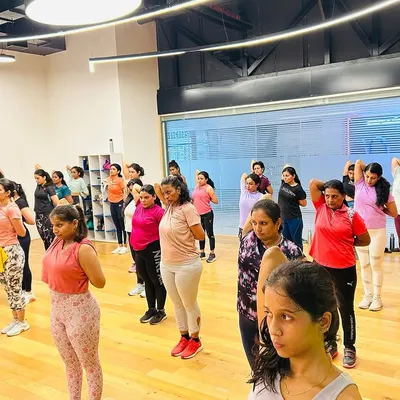 A wide shot of our vibrant group class at Bhartiya Mall. You can see the focus and energy as we move through a strength and conditioning routine together in a spacious, modern studio.