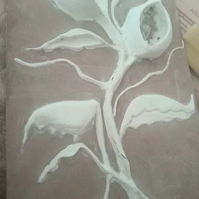 Every great artwork starts with a strong foundation. Here, you can see the initial stage where we sculpt the basic floral structure onto the board using my special putty and POP mixture.