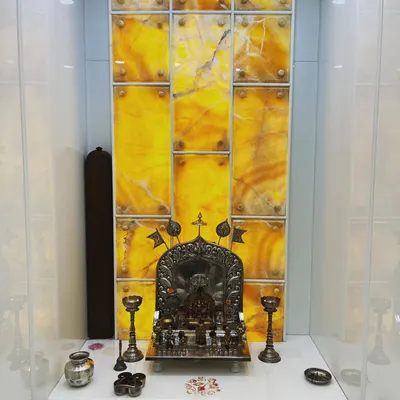 We enhanced this pooja room with a backlit panel of golden Onyx marble. The natural veining of the stone creates a unique, divine glow, making the sacred space feel serene and special.