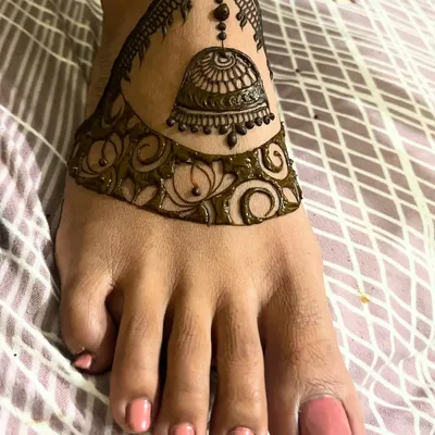 This foot design features a stunning jhumka (bell) created with cutwork, where the dark henna paste makes the skin appear like a highlight.