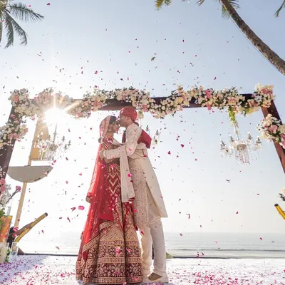 A breathtaking kiss under a shower of petals right after the vows. This shot from a Goa beach wedding captures the peak emotional moment of the ceremony.
