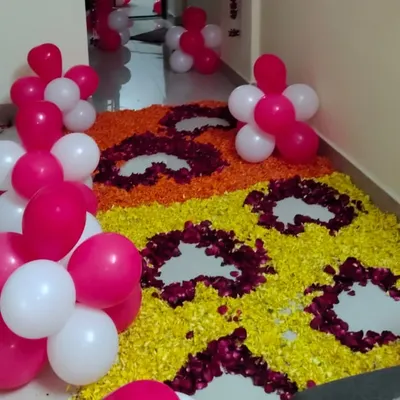 This entrance decor is a great example of a hybrid style. I created a large floor rangoli using marigold and rose petals, and framed it with modern pink and white balloon clusters for a fun and festive look.