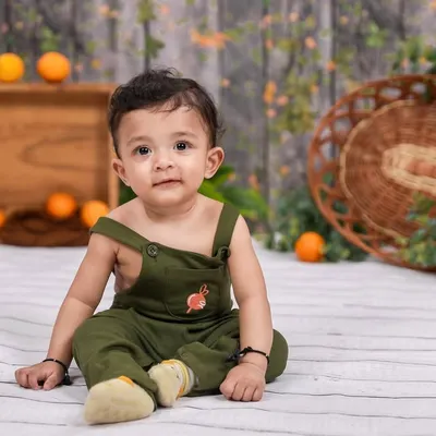 A classic sitter session portrait. This little one is sitting up proudly in our studio, with a simple, rustic background that keeps all the attention on his adorable face.