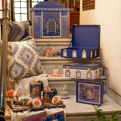 This is a complete suite from the Golden Dunes collection, displayed on a staircase to show its various elements. It includes the main architectural box, smaller favor boxes, and coordinated gift items, all designed to create a cohesive royal narrative.