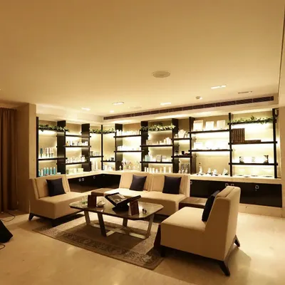 Our client lounge and retail space, featuring elegantly lit shelves with curated wellness products. This area is designed for you to relax and consult with our experts before your service.