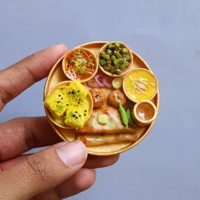 This tiny Kathiawadi thali is a tribute to Gujarat’s rustic flavors, featuring dhokla, sev, and other regional specialties.