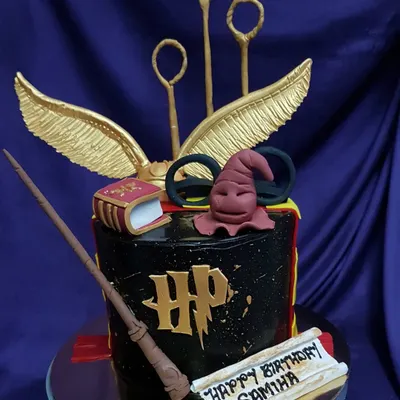 Wingardium Leviosa! This Harry Potter themed cake is pure magic, featuring an edible Sorting Hat, golden snitch, and magic wand. It's the perfect centerpiece for any Potterhead's birthday celebration.