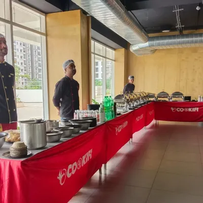Our team setting up the buffet in a modern, well-lit clubhouse. We ensure our setup is clean, professional, and ready well before your guests arrive.