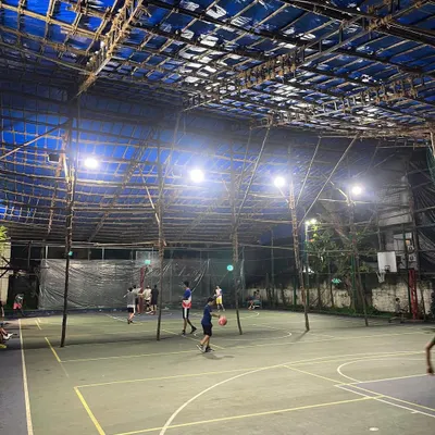 A wide view of our covered basketball court during an evening session. The bright lighting and protected space allow for focused training at any time of day, regardless of the weather.