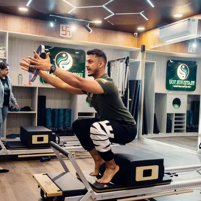 Pilates is not just for women. Here, a male client works on a challenging squat variation, building lower body strength and balance. My classes are designed for everyone.