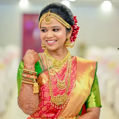 This bride is wearing a full temple jewellery set, including a statement choker, a layered haaram, and a matching oddiyanam (waist belt). It’s a popular choice for achieving that authentic, grand bridal look.