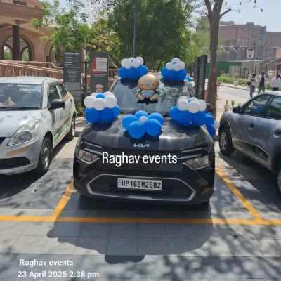 A car decorated with blue and white balloon bunches and a baby boy foil balloon on the hood to welcome the baby home.