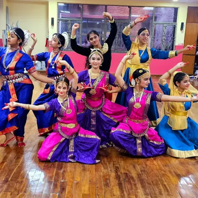 A group of our Bharatanatyam students in full traditional costume, ready for a performance. We emphasize stage readiness, including costumes and makeup.