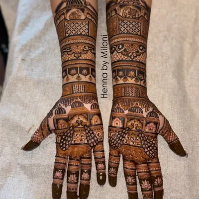 A stunning example of full-coverage bridal mehendi. This design features repeating architectural domes and intricate lattice work, creating a rich and symmetrical look.