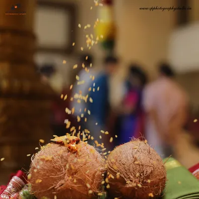 A detail shot of coconuts used in a traditional Hindu ceremony, with rice grains being showered as part of the ritual. We capture the beauty in these symbolic elements.