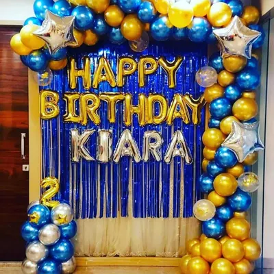 Yeh ek classic birthday decoration hai. Ismein humne blue aur golden metallic balloons ka arch, blue foil curtain backdrop, aur naam ke liye alag se foil letters ka istemal kiya hai.