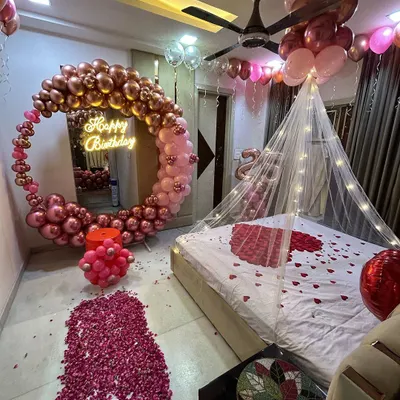 This is the ultimate romantic birthday surprise. I transformed the entire room with a rose gold and pink circular balloon arch, a bed canopy with fairy lights, a path of rose petals, and balloons covering the ceiling. It's a truly immersive and magical experience.