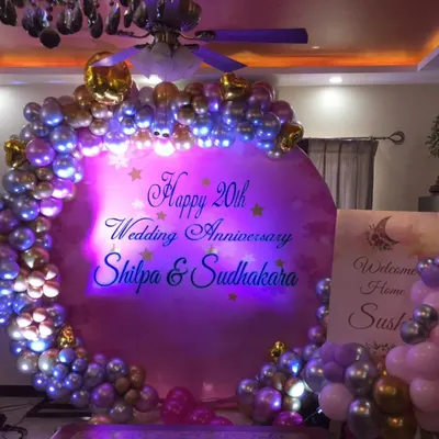 A beautiful setup for a 20th wedding anniversary celebration. I designed a personalized circular backdrop with a balloon garland in silver and pink, creating a wonderful photo booth for the happy couple and their guests.
