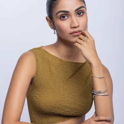 A clean and elegant commercial shot for a jewelry brand. The focus is on the delicate bracelets and the model's sophisticated look.
