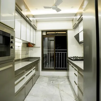 This is a classic parallel kitchen layout, perfect for maximizing storage and efficiency in a compact space. I used a combination of laminate shutters, profile doors with back-painted glass, and sleek aluminum handles.
