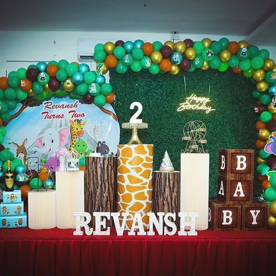 Welcome to the jungle. This 'Wild One' safari theme birthday features a lush green backdrop, animal cutouts, and wood-textured props for a fun adventure.