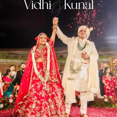 The moment of victory and union. The couple raises their hands in celebration after the Varmala exchange, showered in confetti and love.