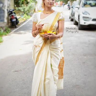 A classic Kerala saree draping for an Onam look. The off-white and gold combination is timeless, and the drape is kept simple and elegant.