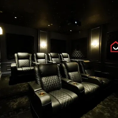 A glimpse into a super-luxury 7.2.4 home cinema in Kanchipuram, featuring Denmark's M&K audio solution. The room is defined by its dark, classic aesthetic with diamond-stitched leather recliners.