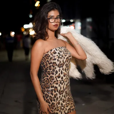A night shoot on a city street for a fashion brand. The combination of the leopard print dress, faux fur jacket, and eyeglasses creates a bold, edgy look that tells a story.