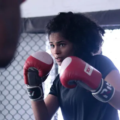 Focus and precision in her eyes. Here, a student practices her boxing combinations, honing the timing that makes a good striker great.