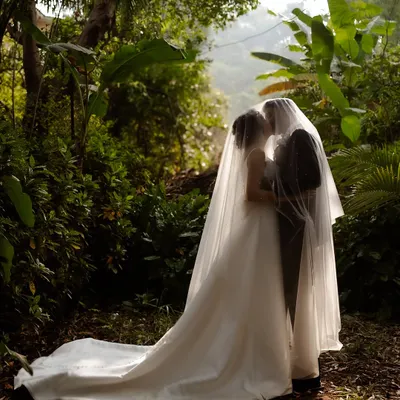 A truly magical portrait, with the couple enveloped in the bride's veil, creating a private, dreamy world of their own.