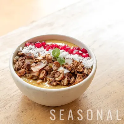 Our seasonal mango smoothie bowl is a perfect tropical start to any day. It's topped with our crunchy house-made granola, fresh pomegranate, and shredded coconut for texture and flavour.