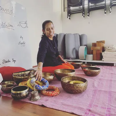 Our sound meditation facilitator, Aarthi, prepares for a session. Each bowl is carefully selected and placed to create a layered, harmonious experience that guides participants into deep states of rest and self-healing.