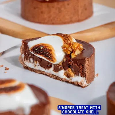 My S'mores Tart is a sophisticated take on a campfire classic. A crisp chocolate shell holds a molten dark chocolate ganache, hazelnut praline, and is topped with a toasted marshmallow swirl.