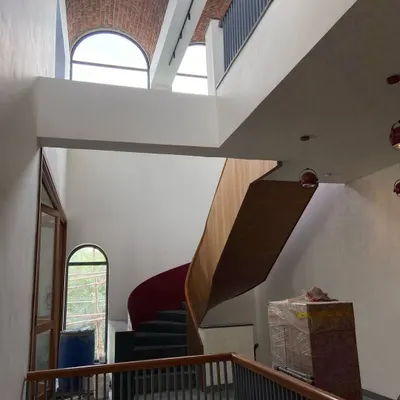 A view of the feature spiral staircase as it transforms from rectilinear to curvilinear, set against the backdrop of a massive 30-foot-long exposed brick vault.