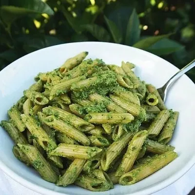 A fresh bowl of penne pasta tossed in a vibrant green pesto sauce. This is a delicious and popular option from our live continental food station, perfect for any event.