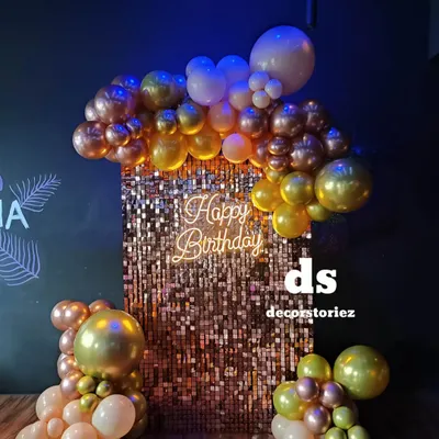 We love creating glamorous party backdrops like this shimmering gold sequin wall. Paired with a 'Happy Birthday' neon sign and a cascade of metallic balloons, it creates a fantastic focal point.