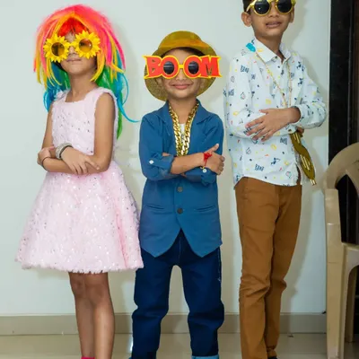 My prop box is always a party highlight. These kids are having a blast posing with a rainbow wig, funky glasses, and a cool gold chain.