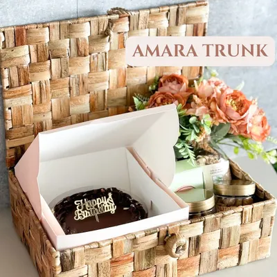 Our Amara Trunk is the perfect birthday surprise. It features a rich chocolate cake with a "Happy Birthday" topper, nestled inside a reusable wicker trunk with other gourmet goodies.