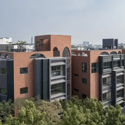 The ARCUS residential building in Chennai, shown here in its urban context. The design uses a combination of brick and dark panels to create a contemporary facade that stands out while respecting the scale of the neighborhood.