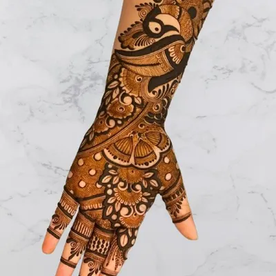 A beautiful design for the back of the hand, featuring a peacock and butterfly, perfect for a sangeet or festive party.