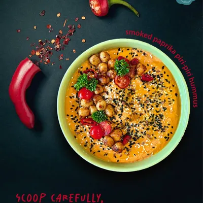 My Smoked Paprika Piri-Piri Hummus, styled for a dramatic effect. This dip has a serious kick, made from red bell peppers smoked to perfection and blended with bold spices for those who love the heat.