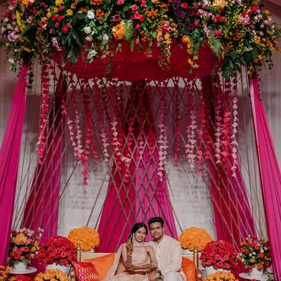 The centerpiece of our 'Hues of Love' Mehendi was this stunning seating area for the couple. Draped in vibrant pink fabric and crowned with a lush canopy of fresh flowers, it was the perfect spot for photos and rituals.