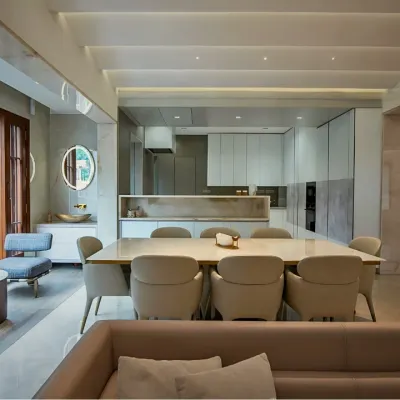 An integrated living and dining area where a neutral palette is warmed by natural wood and abundant light. The open-plan layout connects the sleek, modern kitchen to the rest of the home, making it perfect for both daily life and entertaining.