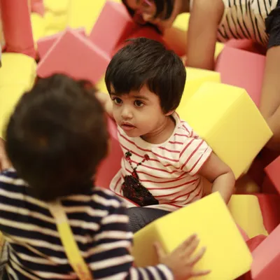 Two children share a moment in our foam pit, surrounded by soft, colorful blocks. It's a great space for imaginative play and making new friends.